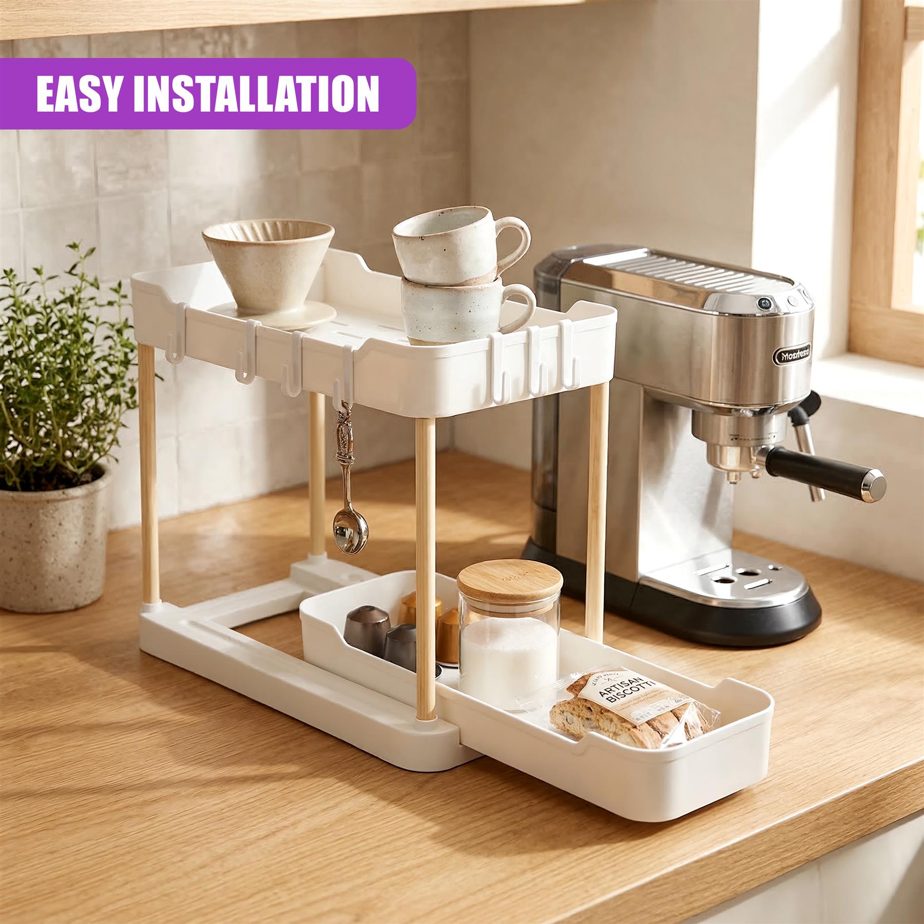 Two-tiered white kitchen organizer unit holding cups, scoops, sugar jar, and biscuit storage tray.