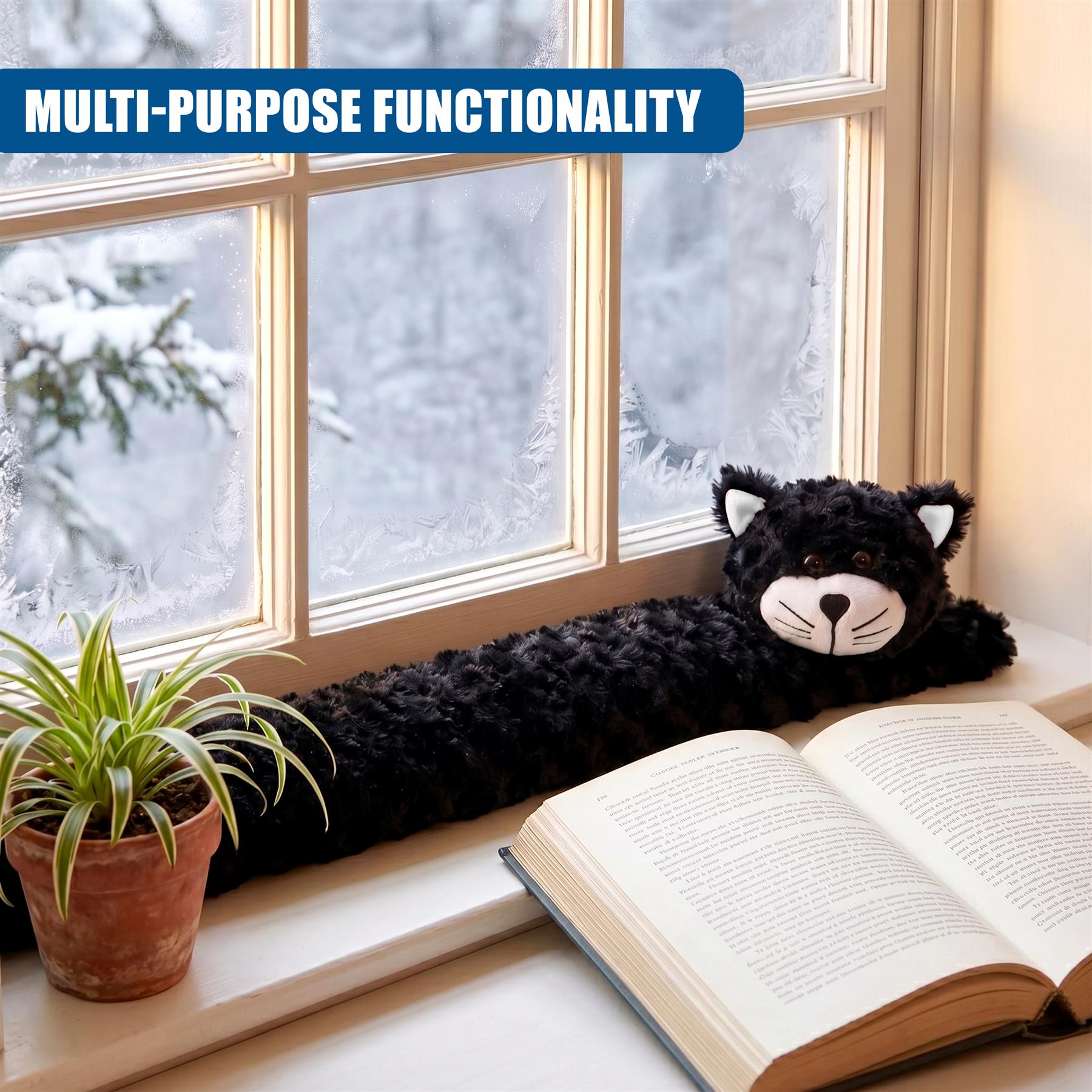 Black plush cat rests on a windowsill near an open book and a potted houseplant.