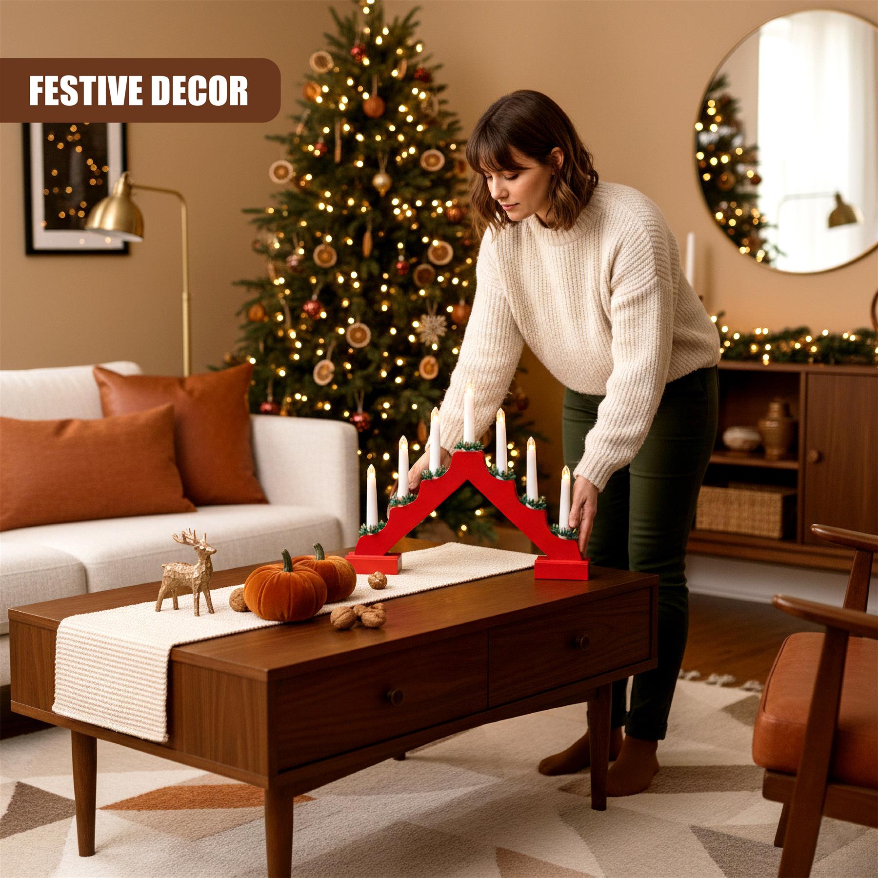 A woman is placing a red, wooden, multi-armed candle holder on a wooden coffee table. The candle holder has seven candle holders, each with a white candle. The room is decorated with a Christmas tree, a couch, a coffee table, and a coffee table runner. - The Magic Toy Shop