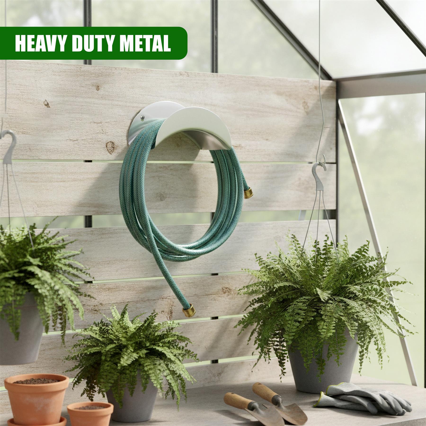 Teal metal curved hose hanger mounted on light wood paneling among potted plants.