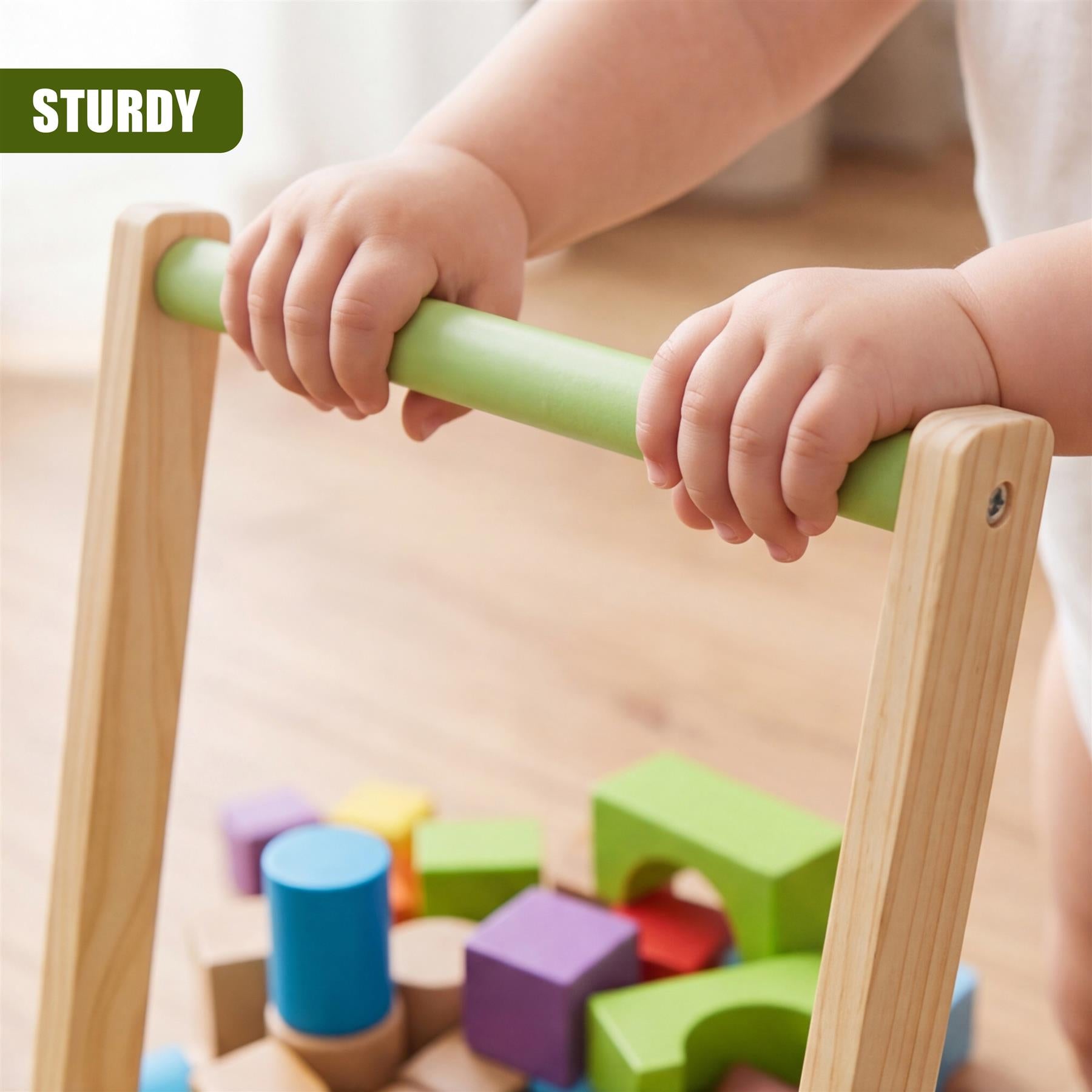 Wooden walker with green handlebar and scattered colorful wooden blocks on a light wooden floor.