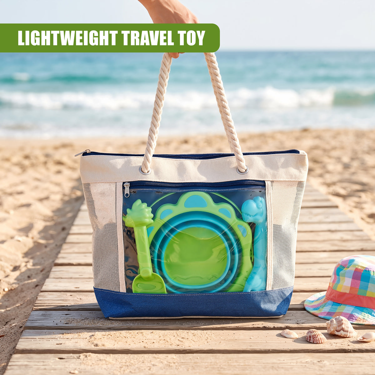 A hand holds a white tote bag with a green collapsible bucket and spade set on a sandy beach