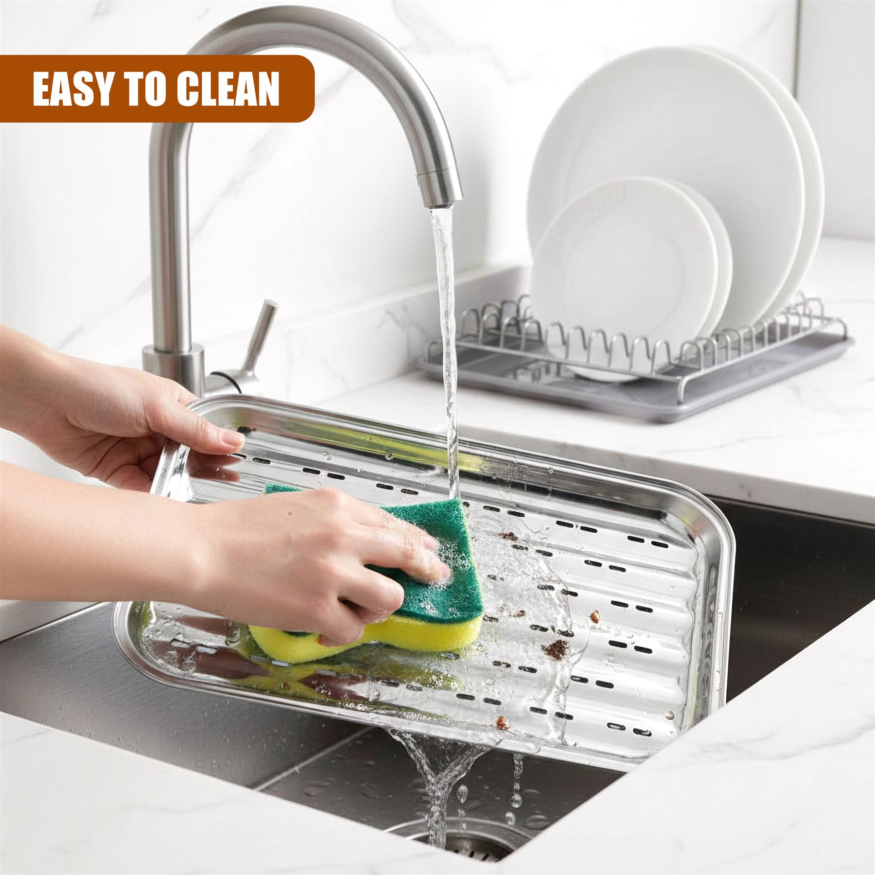 A hand scrubs a stainless steel grill tray in a sink under running water.