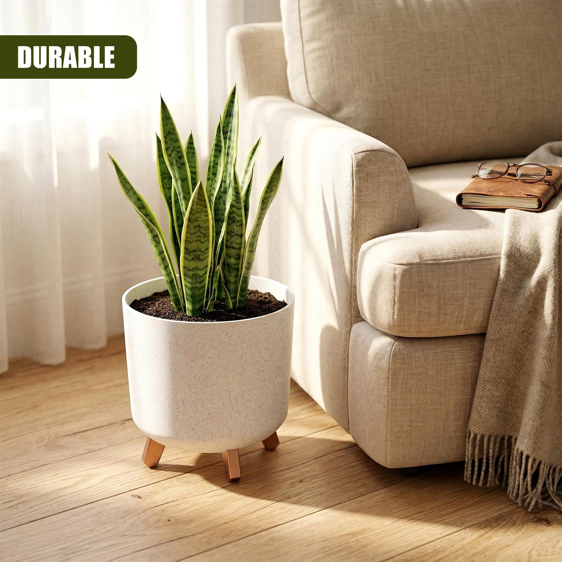 White flower pot with wooden legs displays a potted green foliage plant on a hardwood floor.