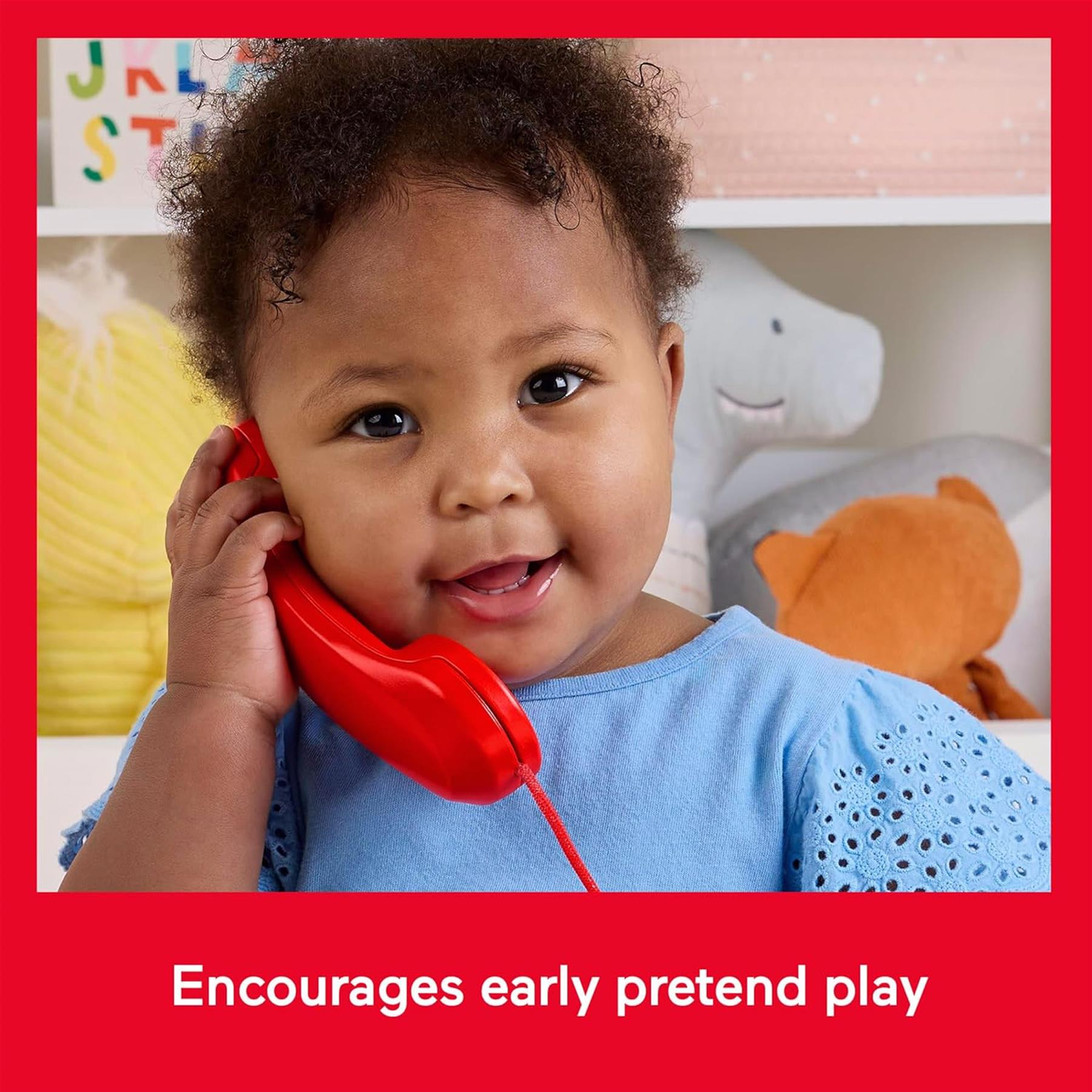 A child holds a bright red toy telephone receiver piece to their ear.