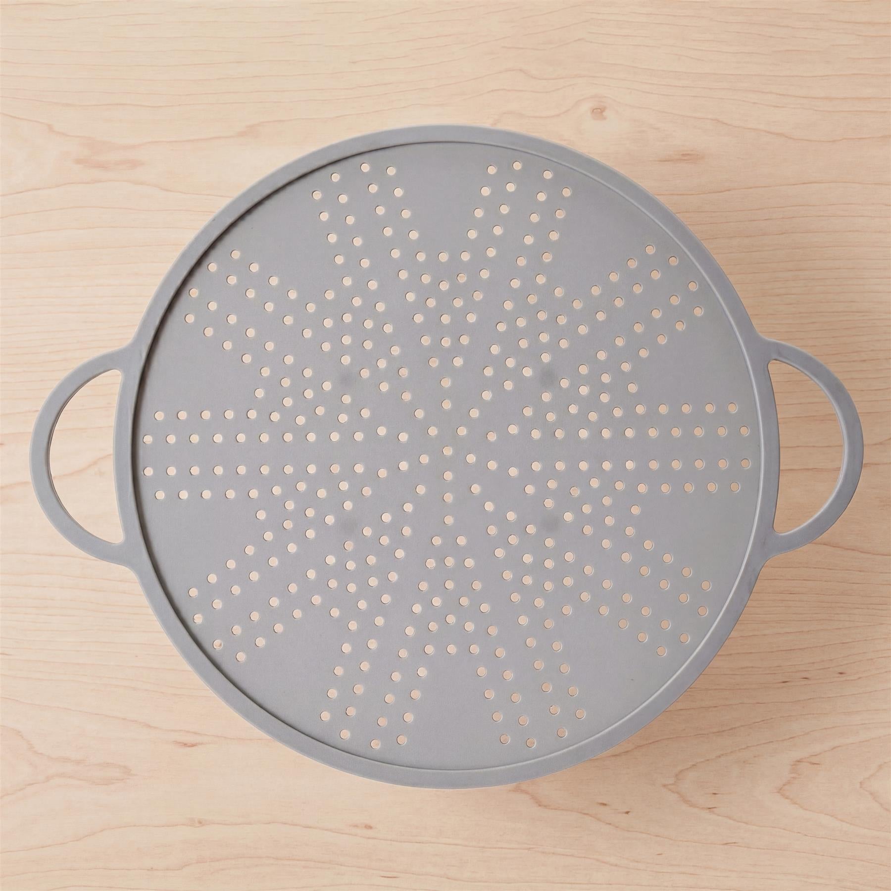 Round, light gray silicone strainer with a perforated surface and two integrated handles.