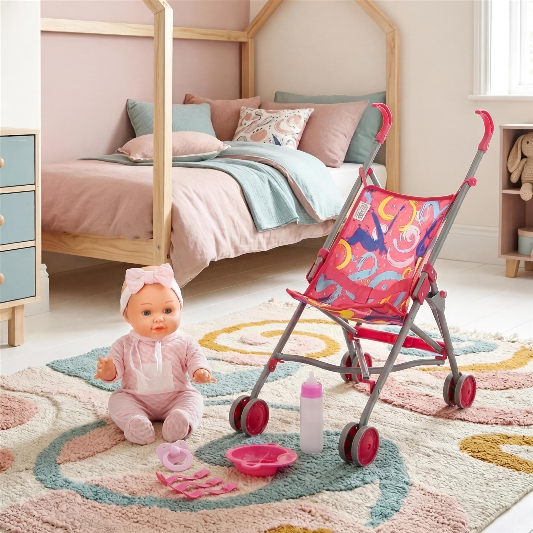 A doll, stroller, feeding bottle, and plates displayed together on a patterned rug.