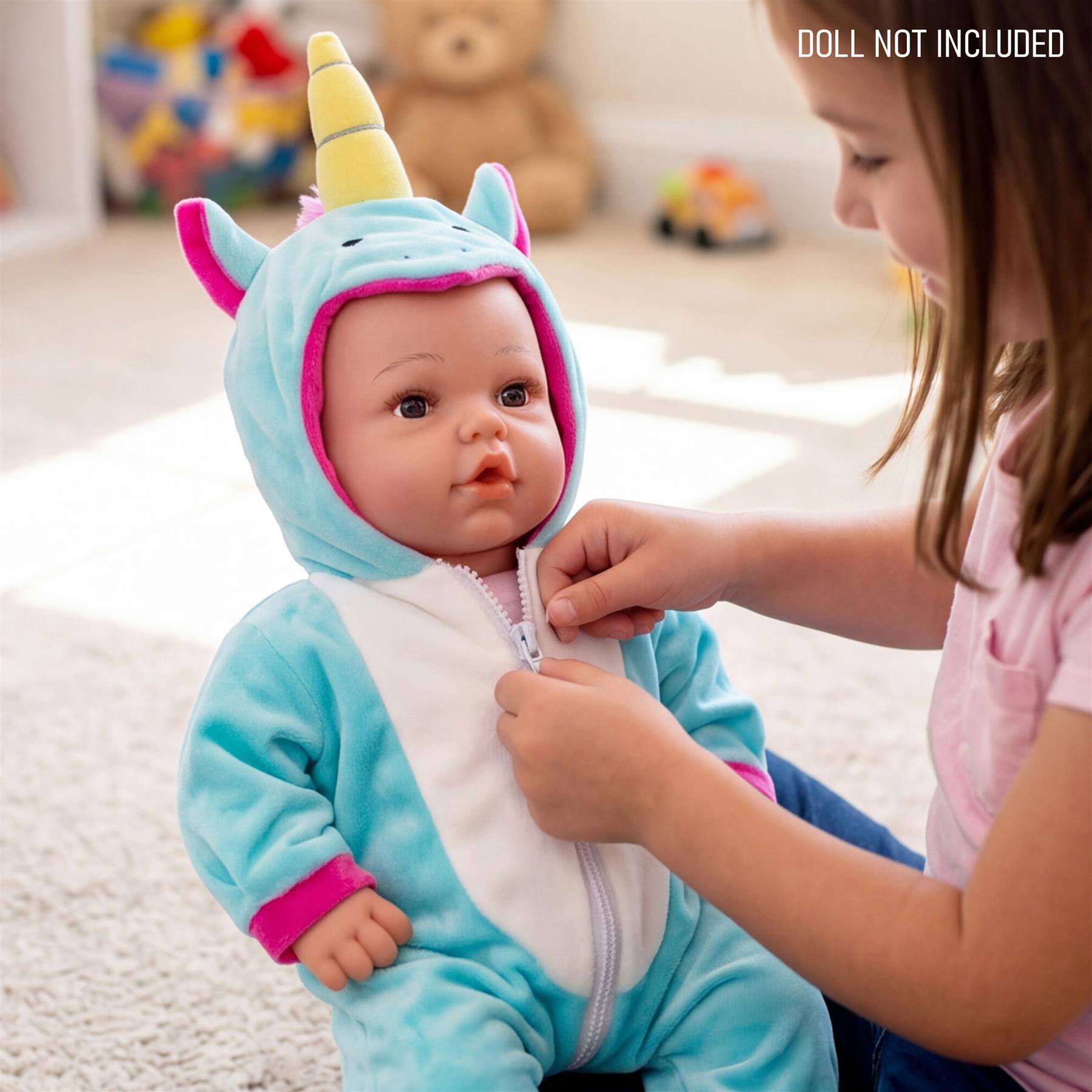 A young girl adjusts the blue and white unicorn hooded outfit on a reborn doll.