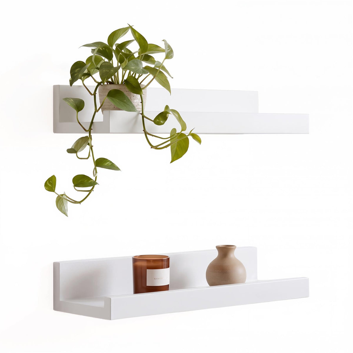 White floating shelves with a plant and vase displayed on them
