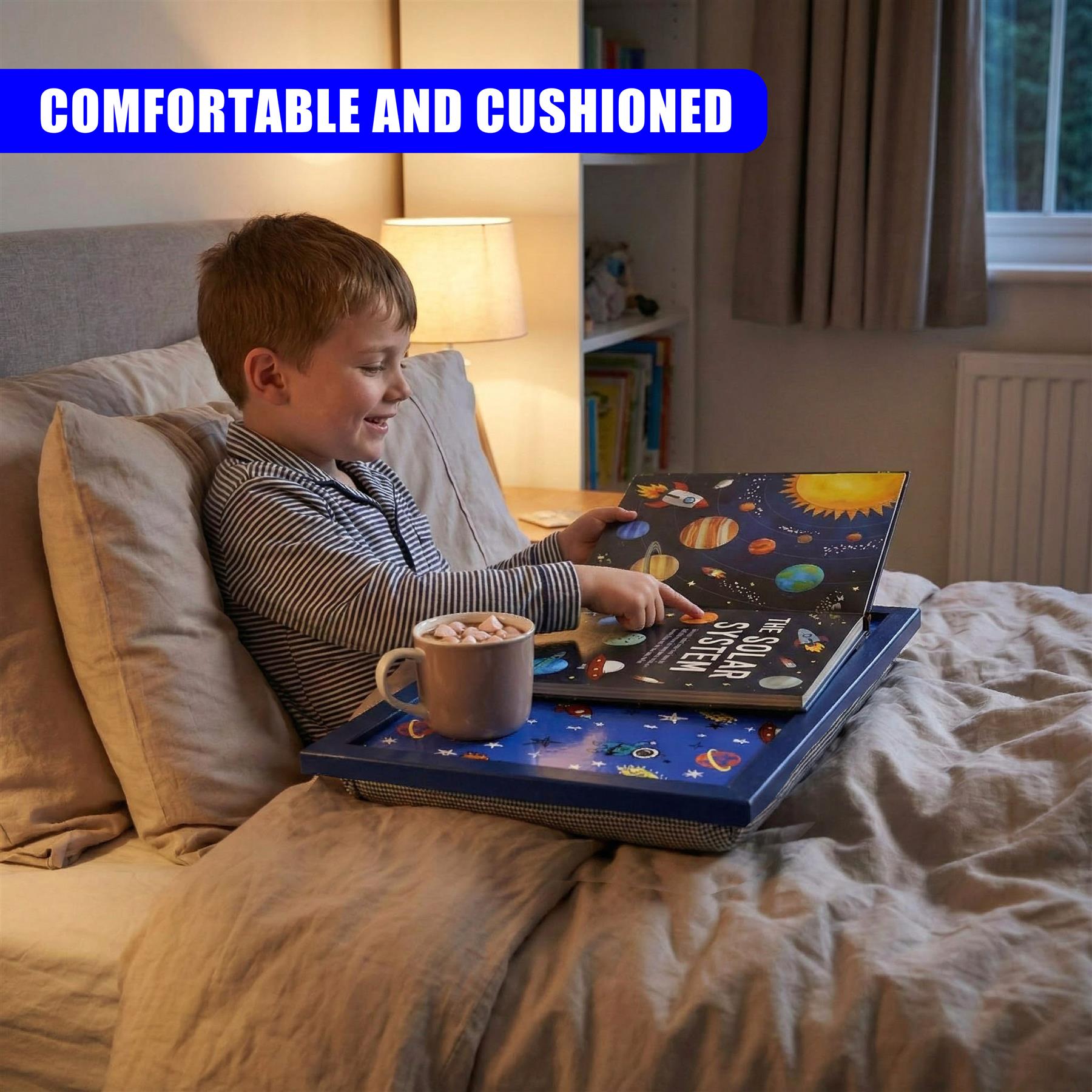 A boy interacts with a blue lap tray featuring a detailed solar system design on a bed.