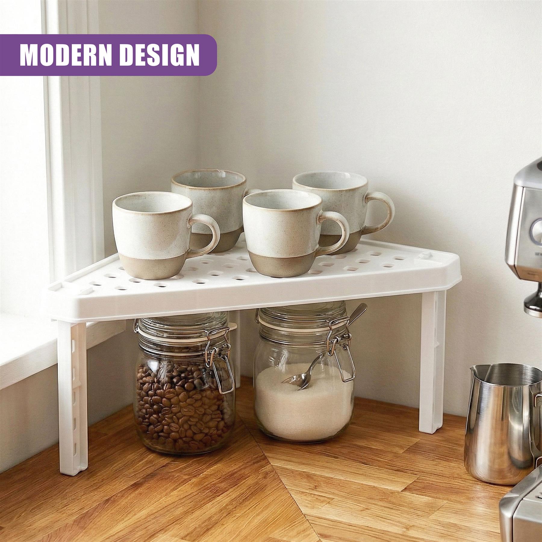 A white shelf display holds multiple mugs and two glass jars containing coffee beans and cream.