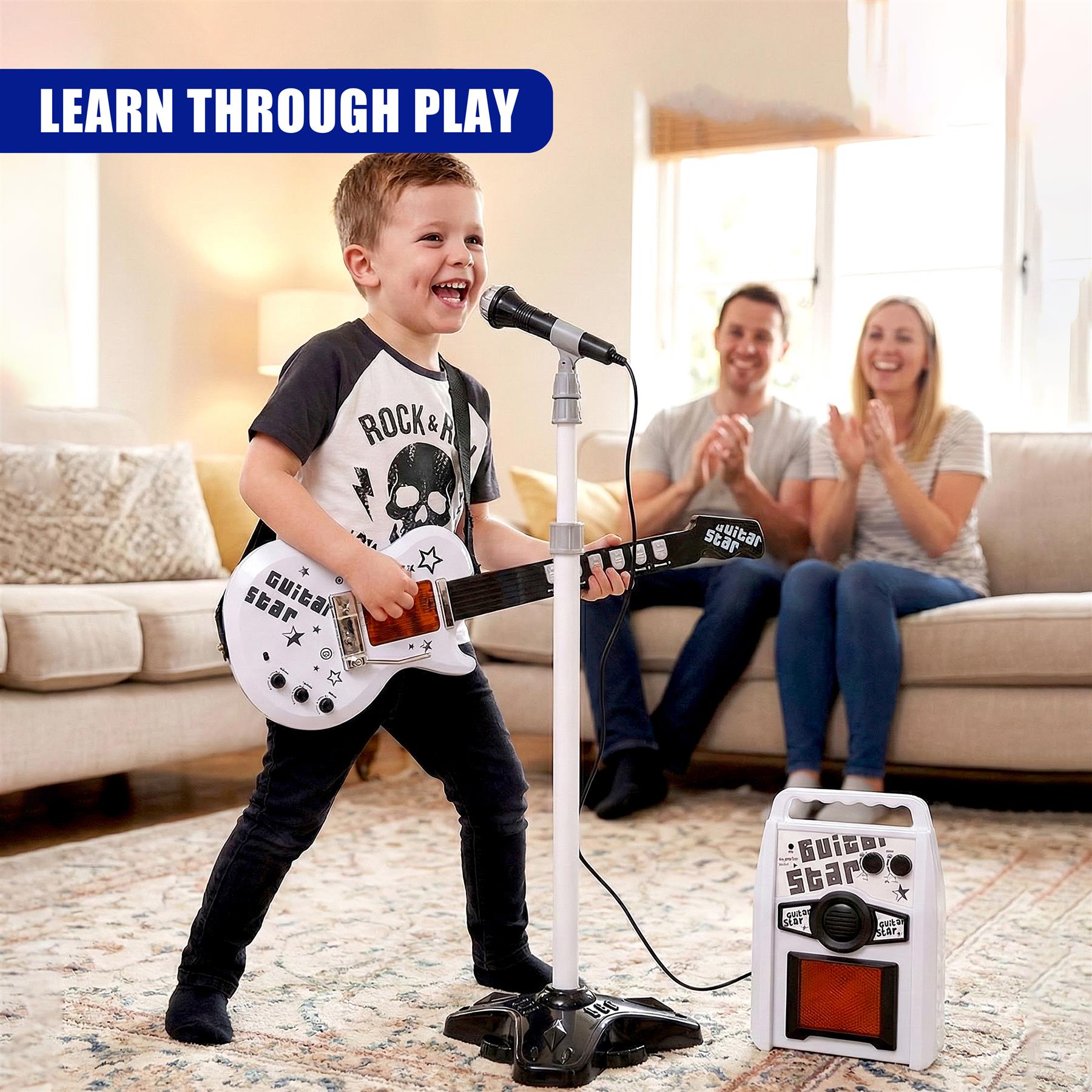 Boy plays a white toy guitar with a microphone and small amplifier.