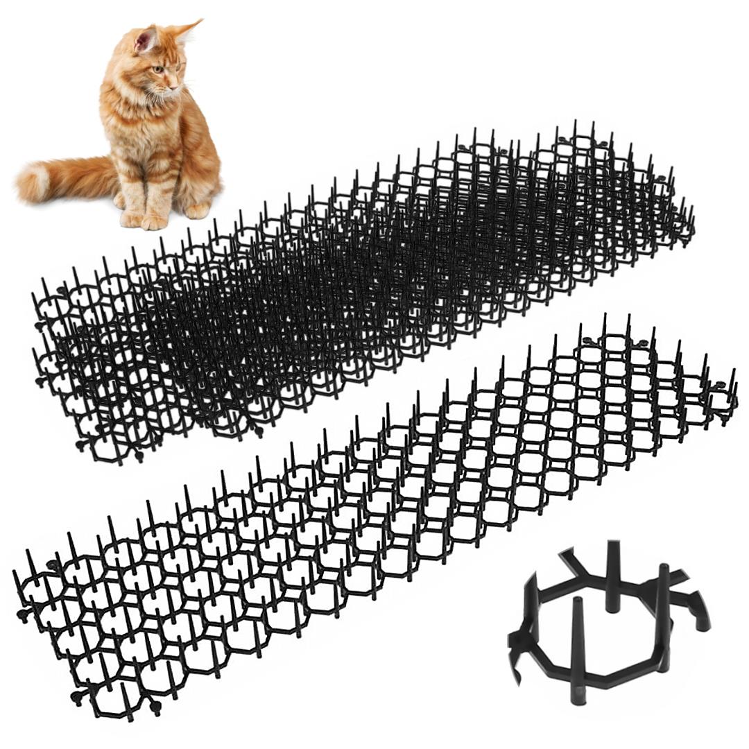 Black animal repellent mats are displayed in the image with their pointed edges visible. A fluffy orange cat sits nearby, looking at the mats. The product includes multiple interconnected pieces designed to deter pets. Designed for gardens or yards, these mats can help protect plants and areas from animal interference. Available at themagictoyshop.