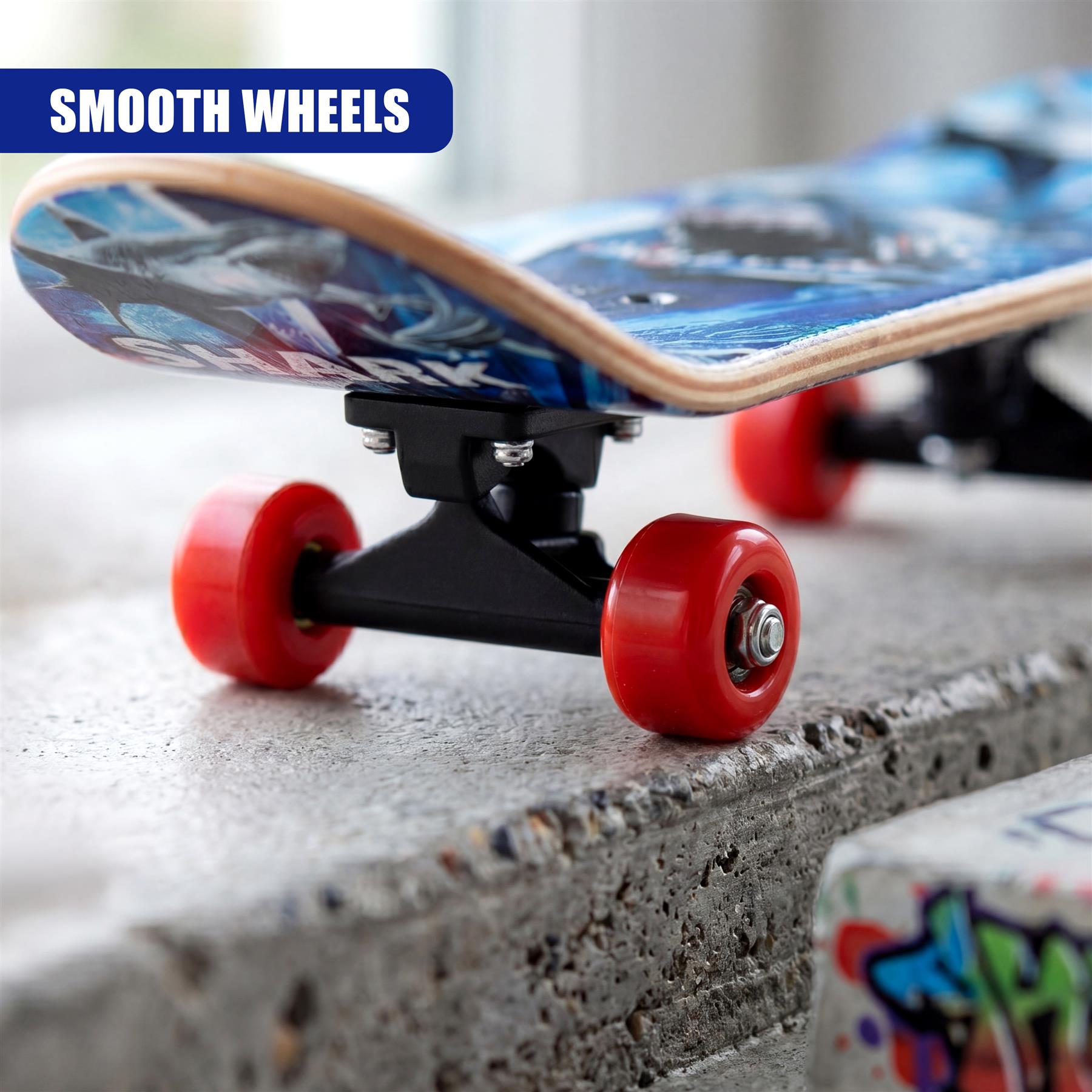 A skateboard featuring a blue graphic deck, black trucks, and red wheels resting on gray concrete.