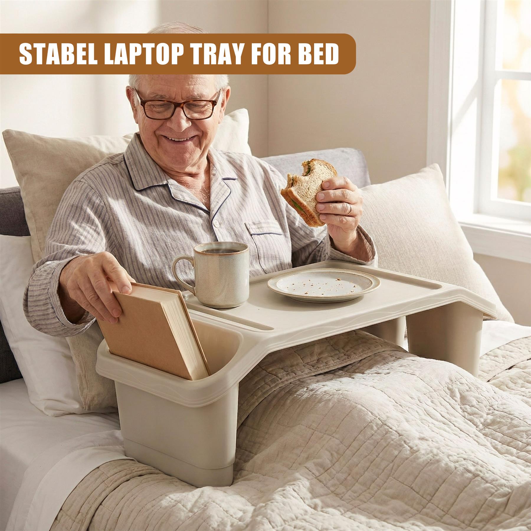 A senior man in bed, using a laptop tray to eat and read. The tray has a built-in cup holder and a storage compartment. The man is wearing a striped pajama and has a comfortable-looking bed with pillows. - The Magic Toy Shop