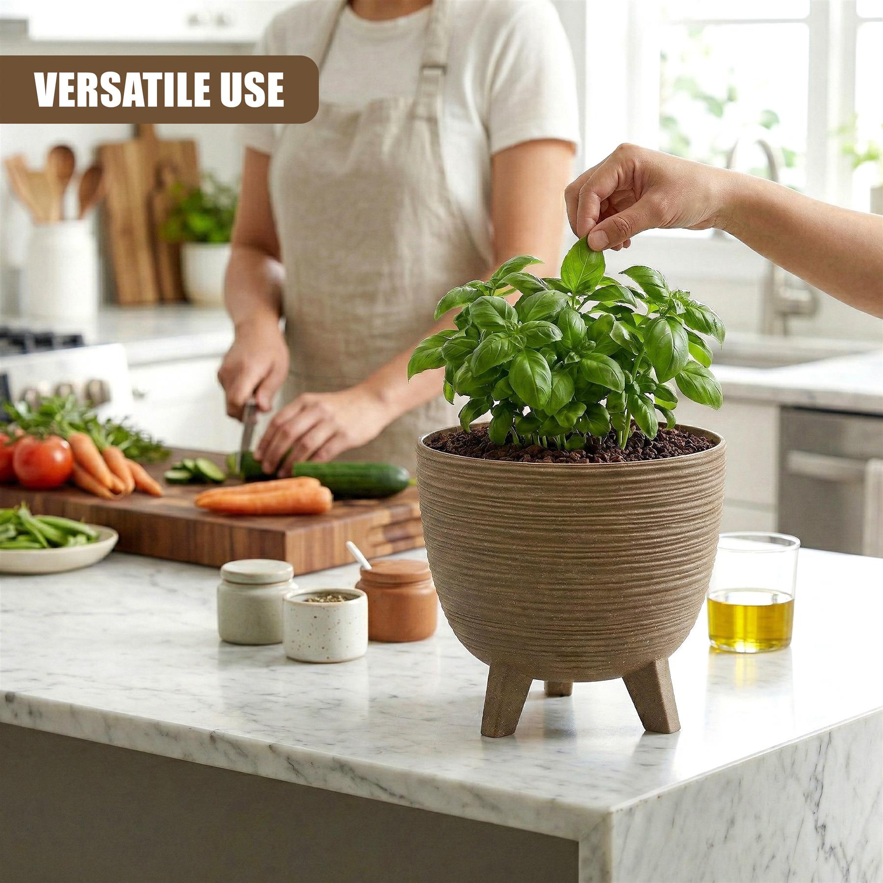 Decorative brown flower pot with visible ridges and three legs, holding fresh green plants on the counter.