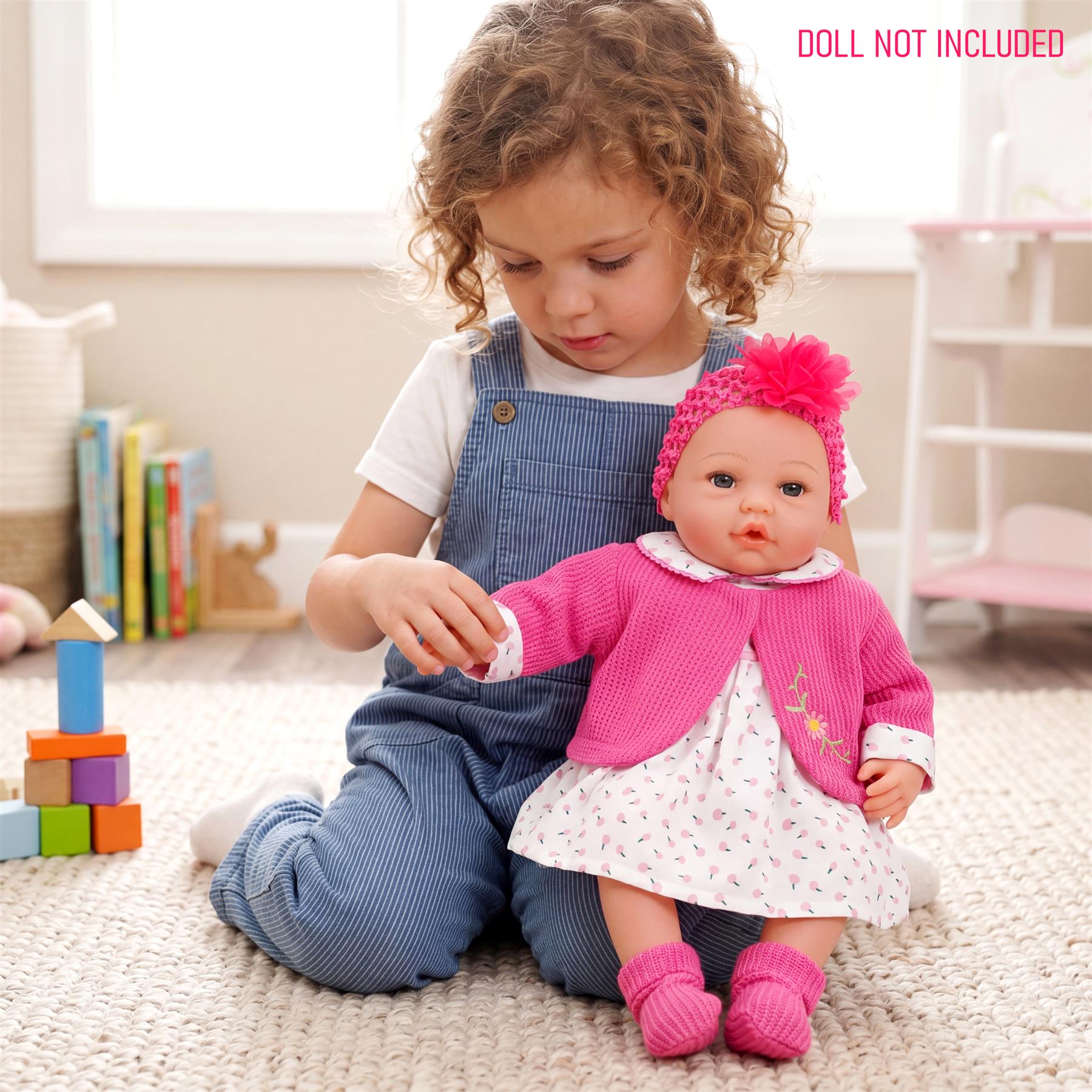 Doll displayed wearing a hot pink cardigan and matching light patterned dress outfit.