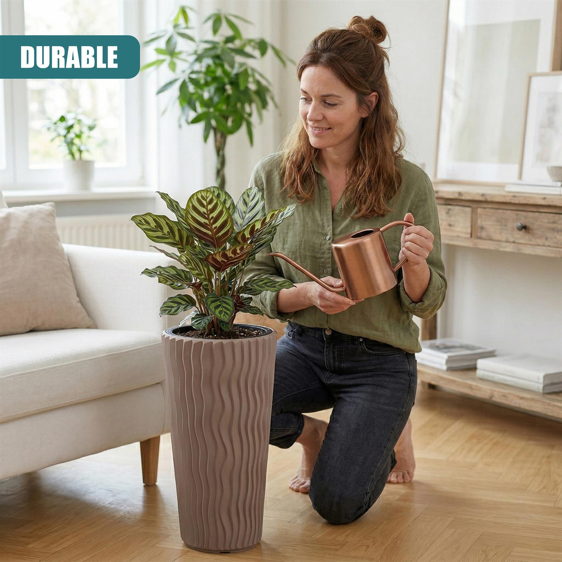 Woman watering a plant potted in a tall, textured brown flower pot in a living room.