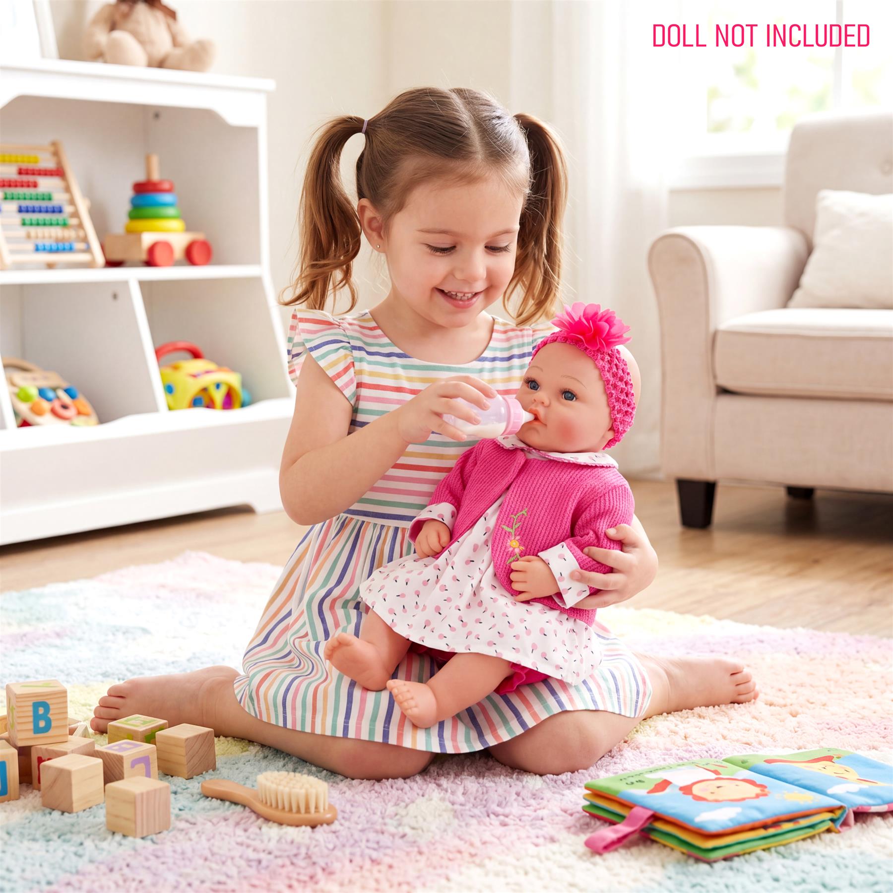 Girl holding a doll wearing a patterned pink and white outfit while seated indoors.