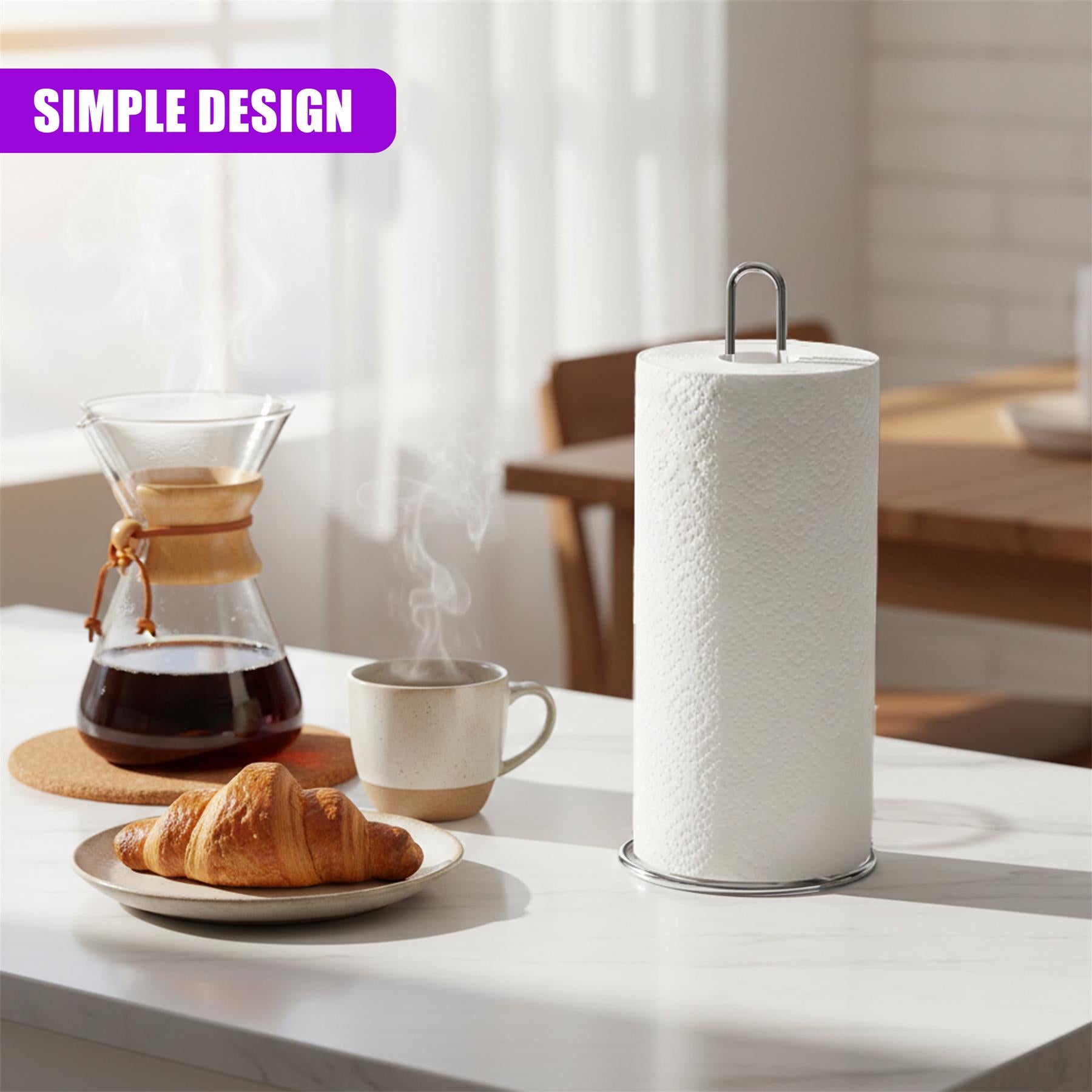 Chrome roll stand, coffee press, steaming mug, and croissant sit on a marble kitchen counter.