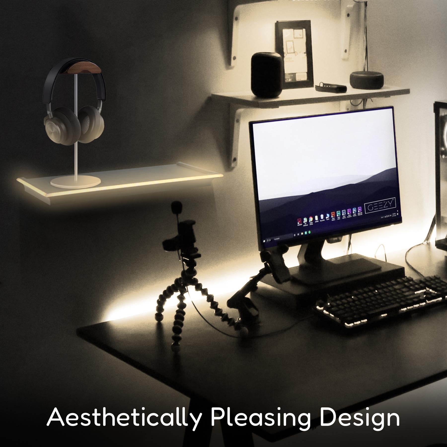 A black floating shelf featuring a sleek design, holding a pair of headphones on a modern stand. In the background, a computer monitor displays a clean desktop, accompanied by a keyboard and a tripod, all set within a stylish room illuminated by LED neon lights. This aesthetically pleasing design enhances any workspace. themagictoyshop