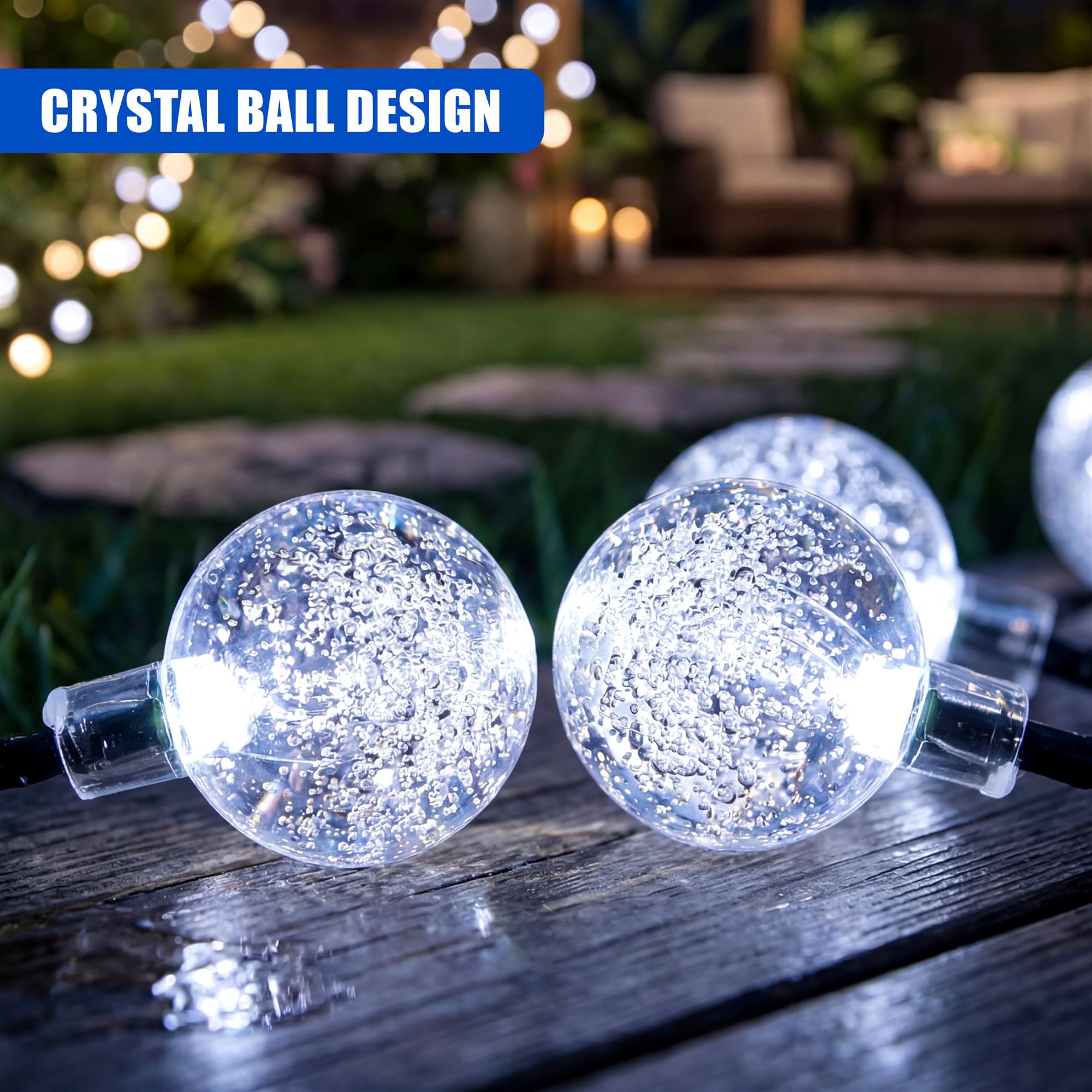 Two glitter-filled crystal globes connect via cords, sitting on a dark wooden surface with blurry background lights.