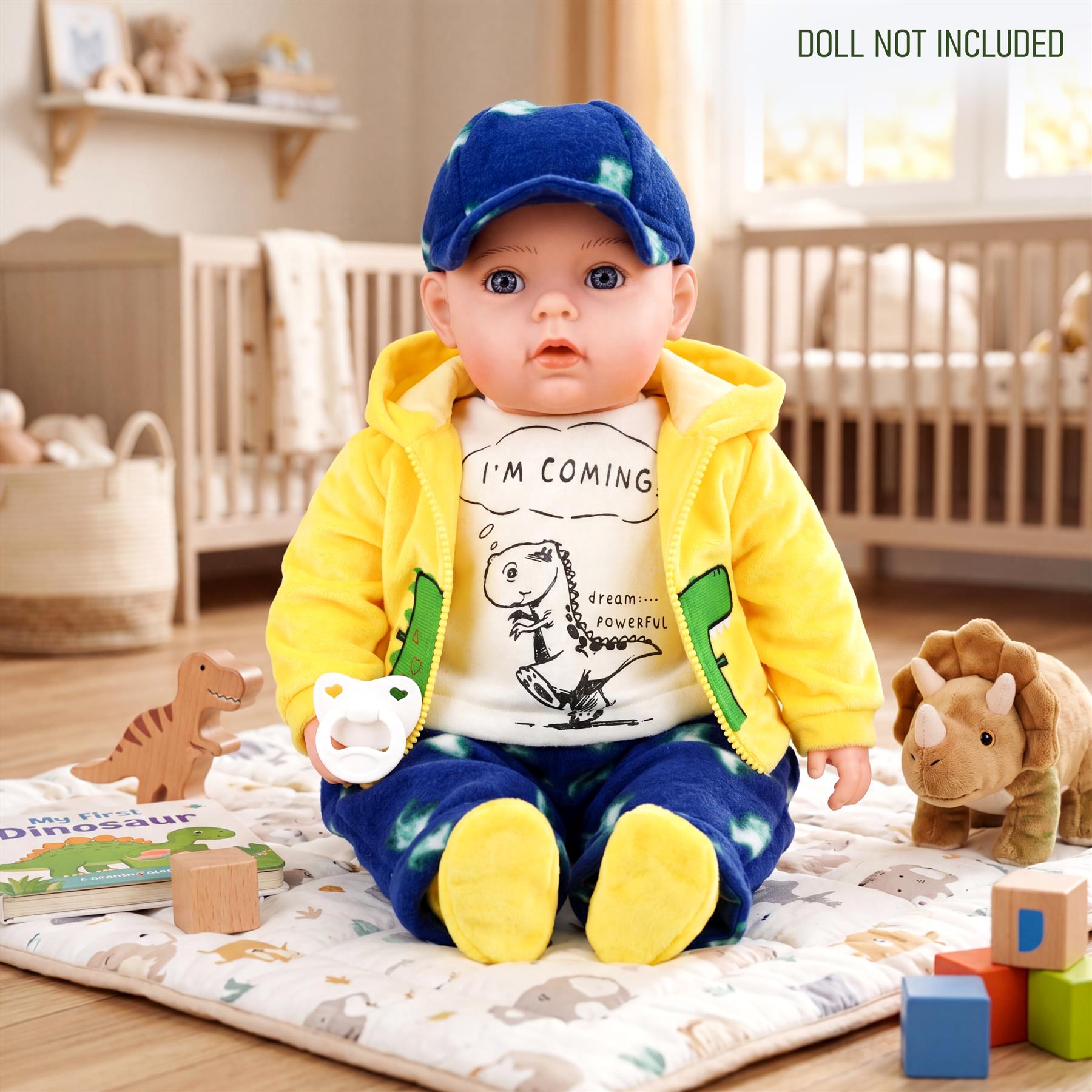 Baby doll wearing a blue cap, yellow hooded jacket, and blue pants is posed with toy dinosaurs.
