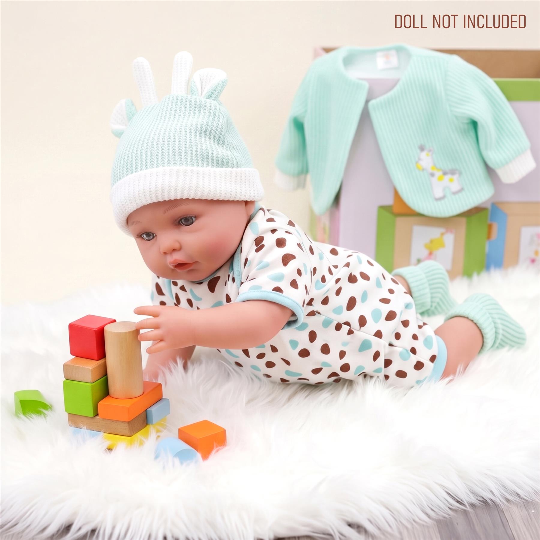 Mint green knitted jacket for dolls is displayed with white embroidered details and accents.