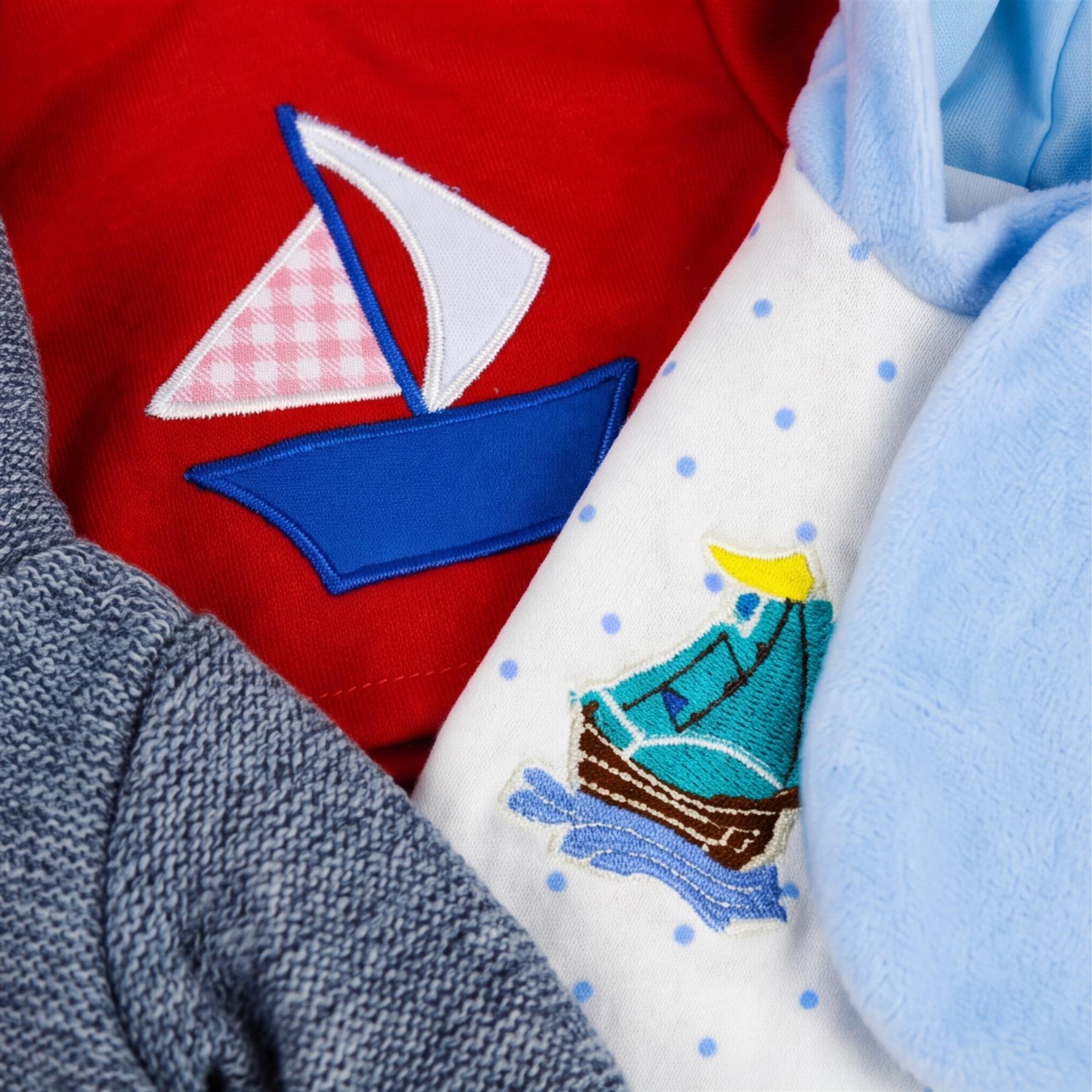 Close up of garments including knit grey fabric, red boat appliqué, and white fabric with embroidered blue boat.