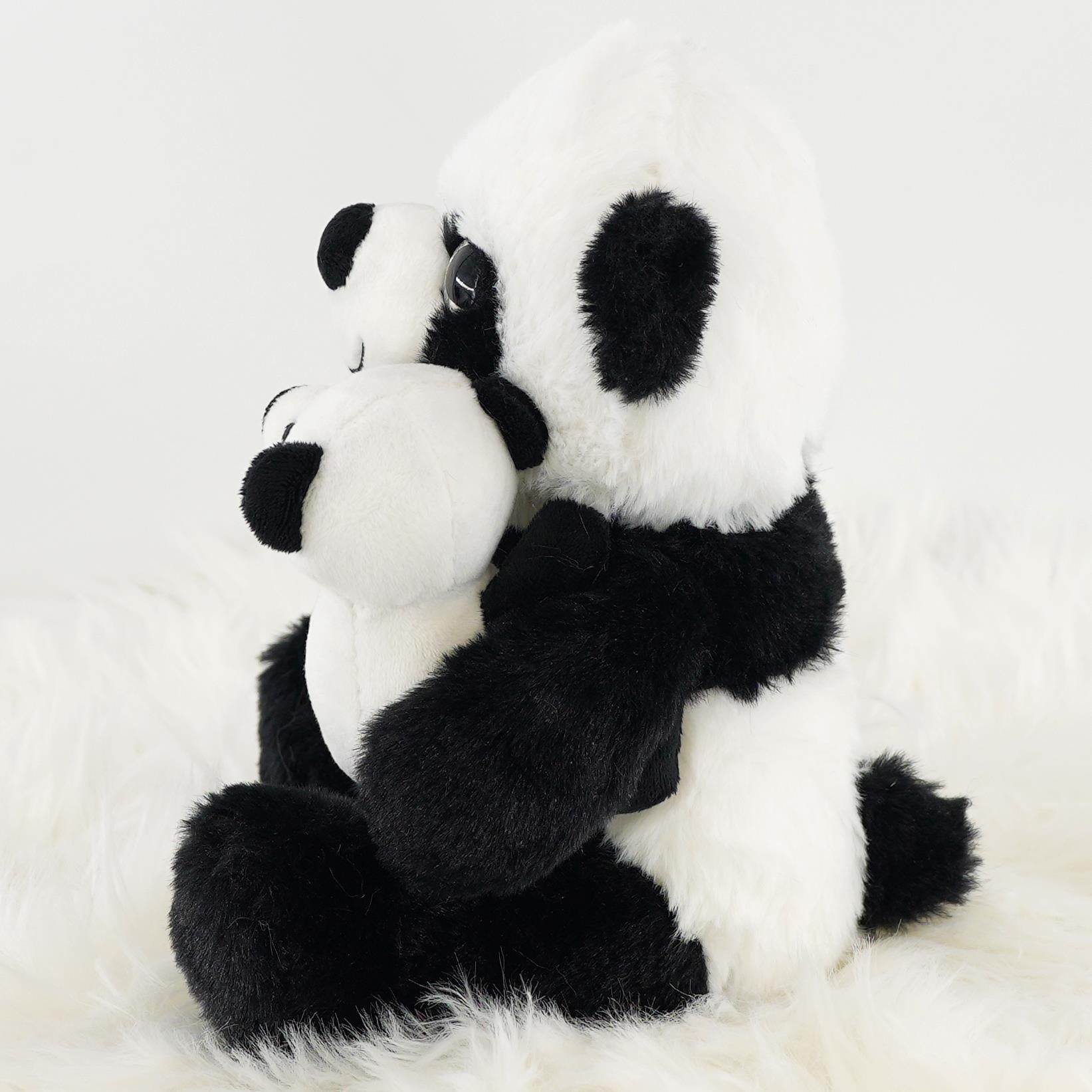 A super soft mommy and baby panda plush toy sitting together, showcasing the adorable features of both pandas, including black and white fur, big round eyes, and cute noses. Ideal for cuddling and playtime, this plush toy makes a perfect gift for children and panda lovers. Available at themagictoyshop.