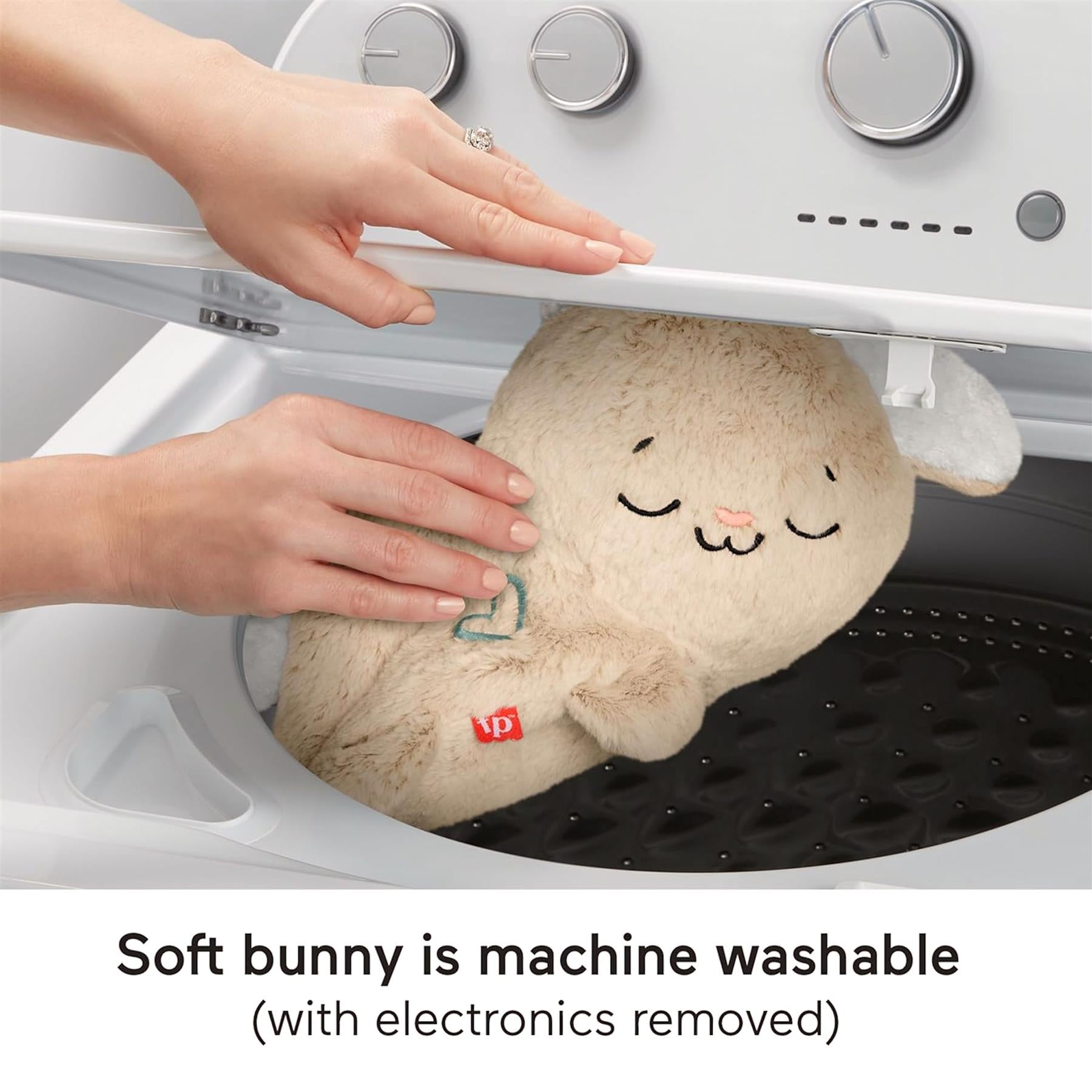 A stuffed bunny plush is placed inside the open drum of a washing machine.