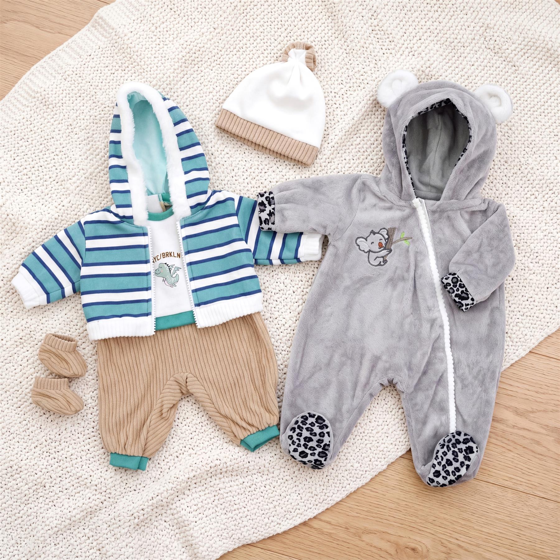 Set of doll clothes including a striped top, knit pants, gray koala jumpsuit, and white hat.