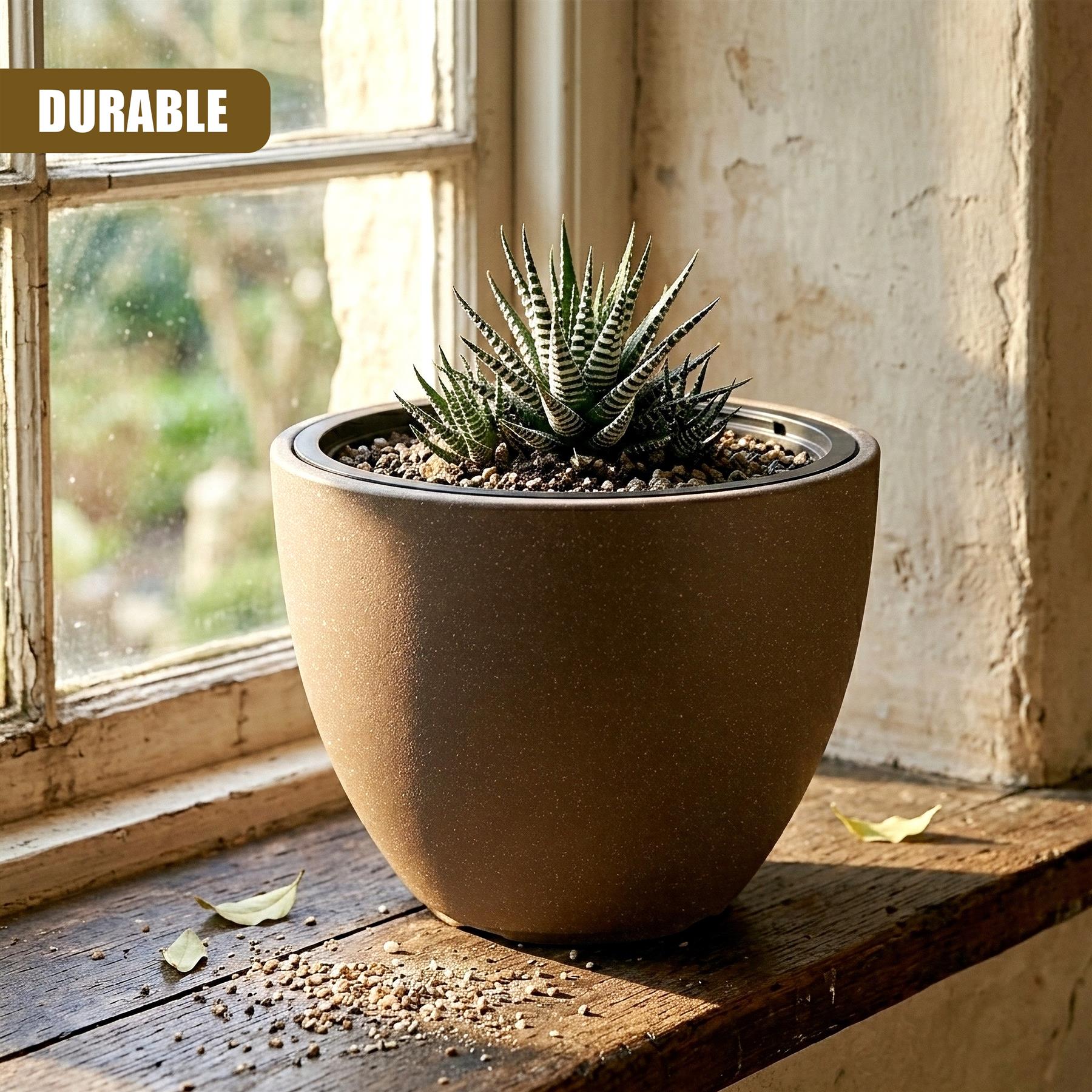 Brown oval pot filled with succulents rests on a wooden windowsill in front of a window.