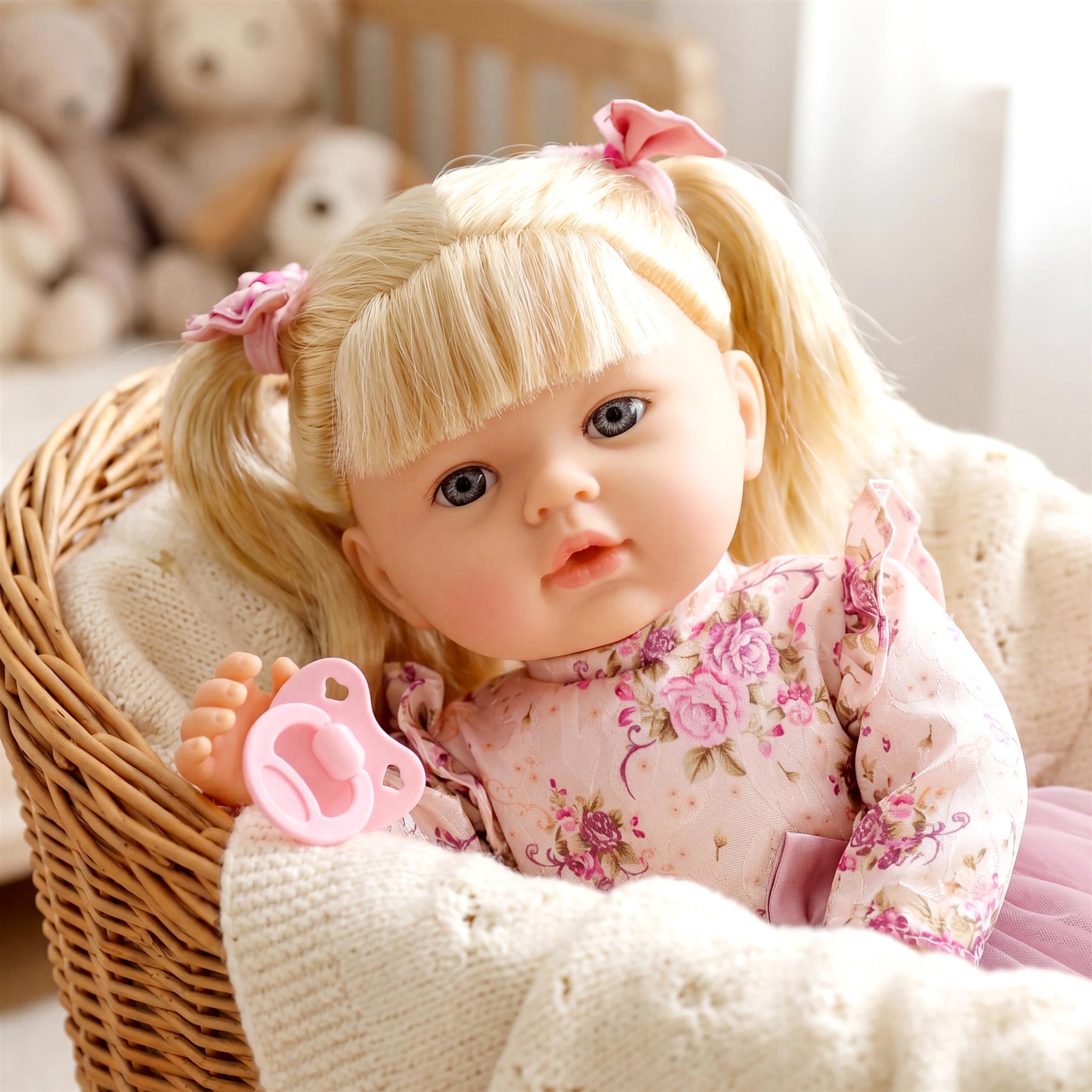 Blonde doll in a floral dress sits in a wicker basket, holding a pink pacifier.