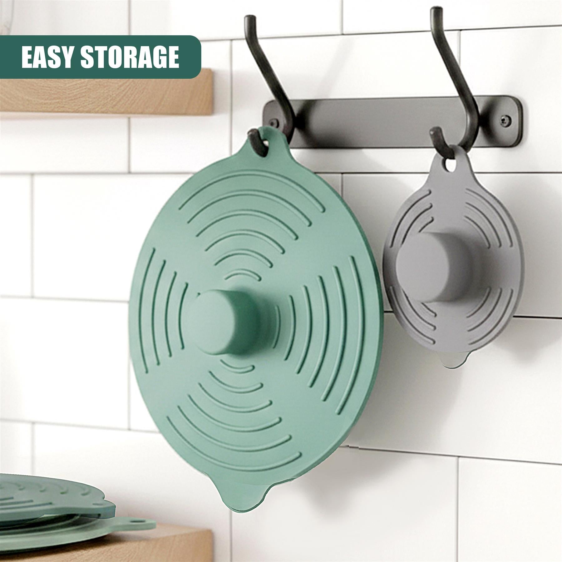 Set of three silicone food covers in mint green and gray, hanging from a metal hook.