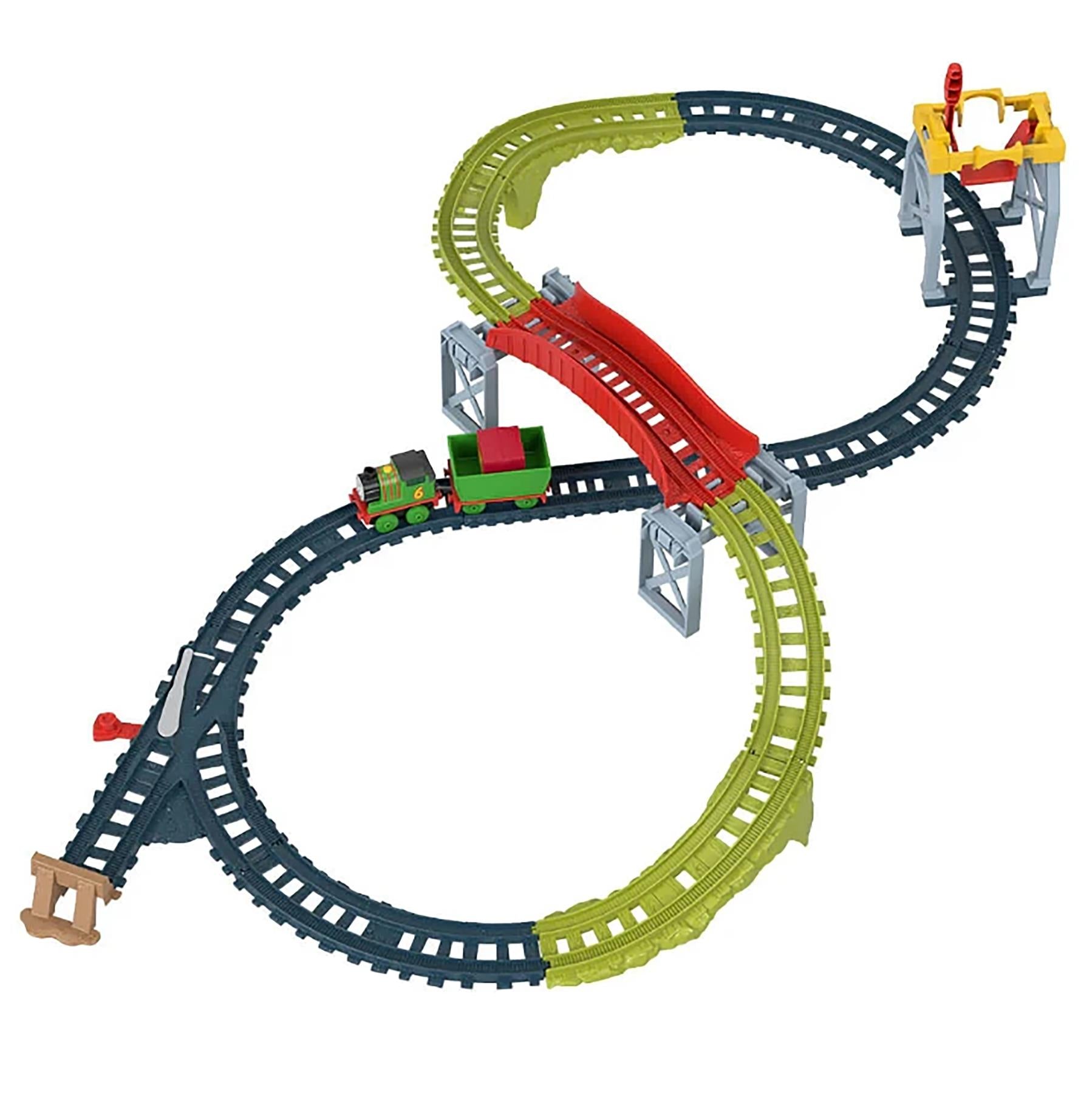 A modular toy train set forming a looping track with cargo drop sections and multiple track colors.