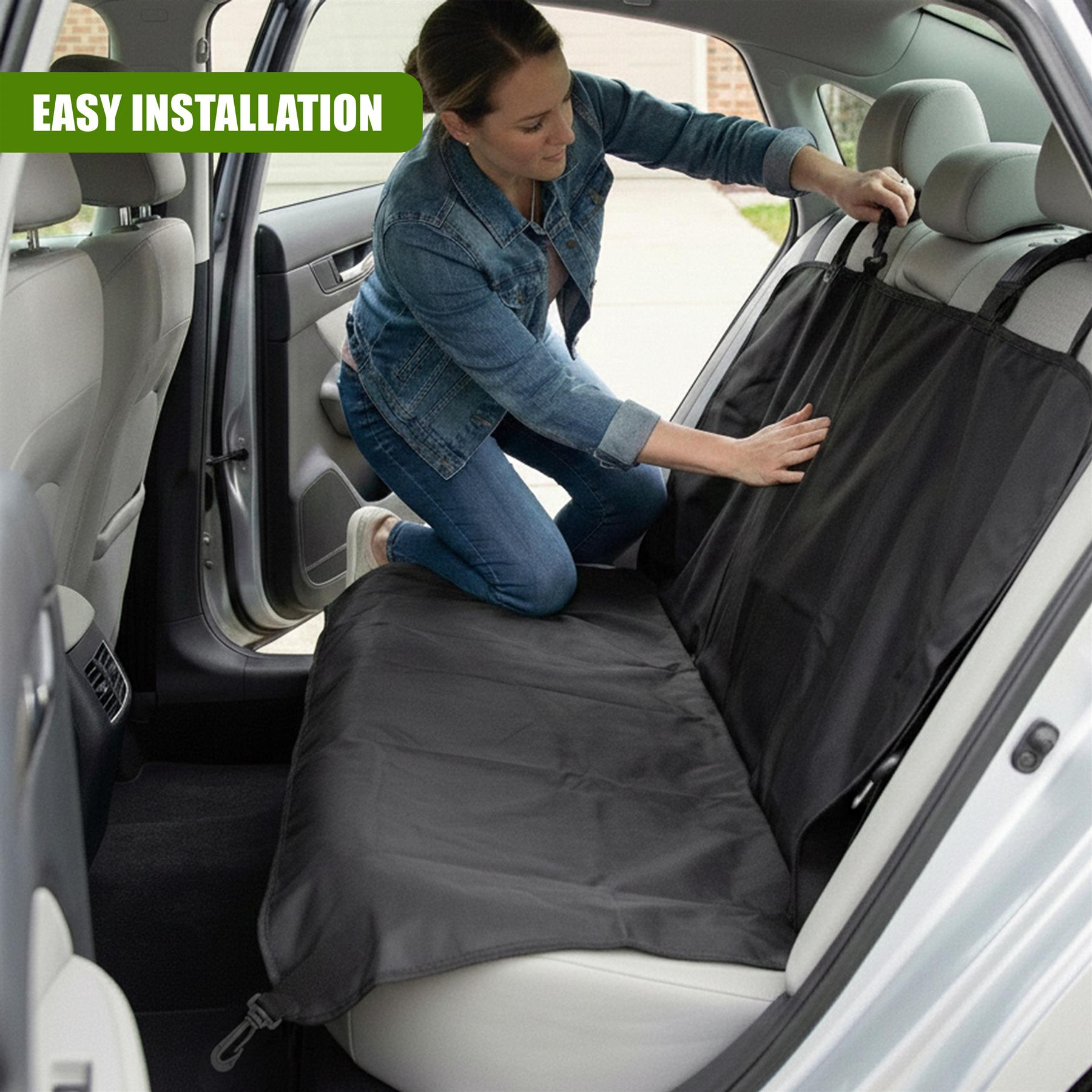 Woman installs black universal dog car seat cover across the vehicle's rear seats.