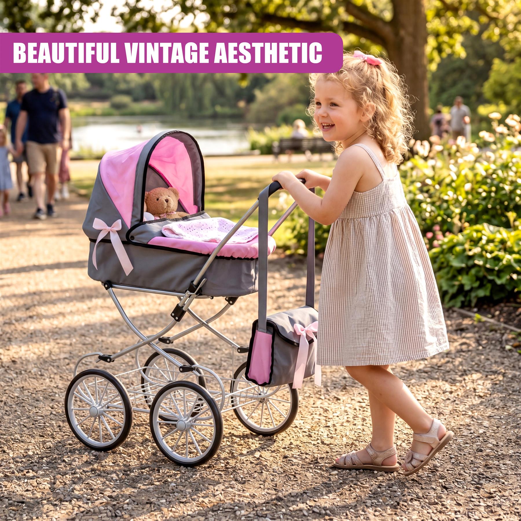 Girl pushing a pink and gray doll's pram with a teddy bear seat on a gravel path.