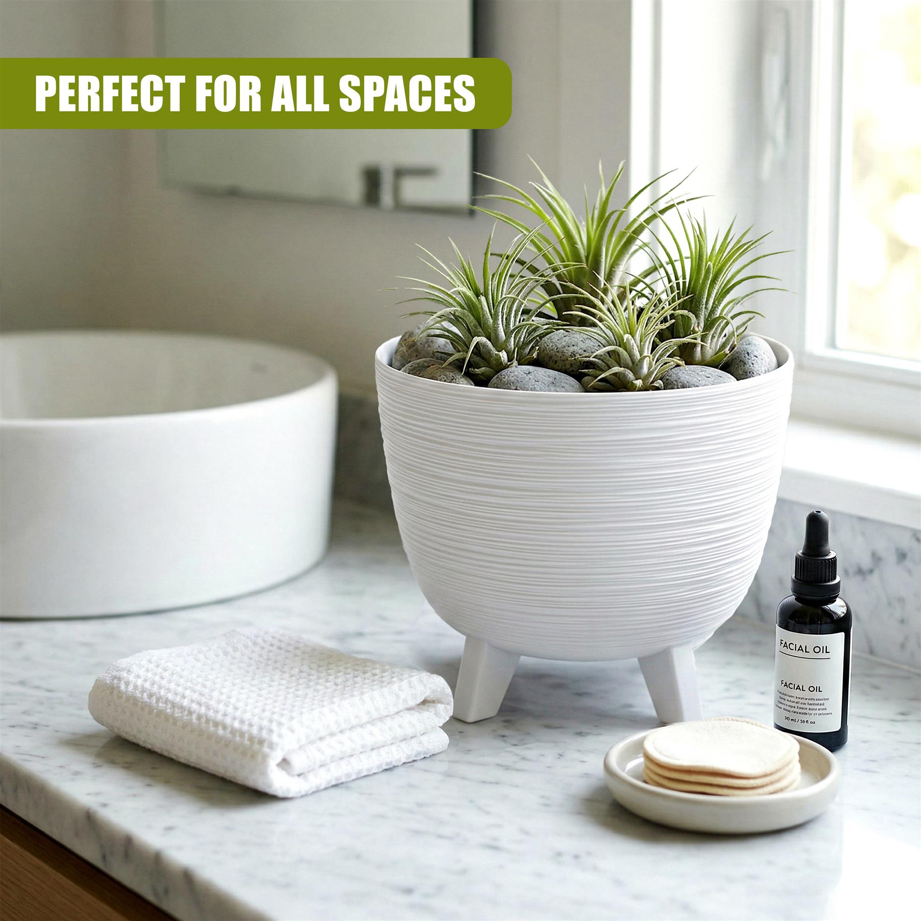 White ribbed pot with legs holds green succulents and stones on a bathroom countertop.