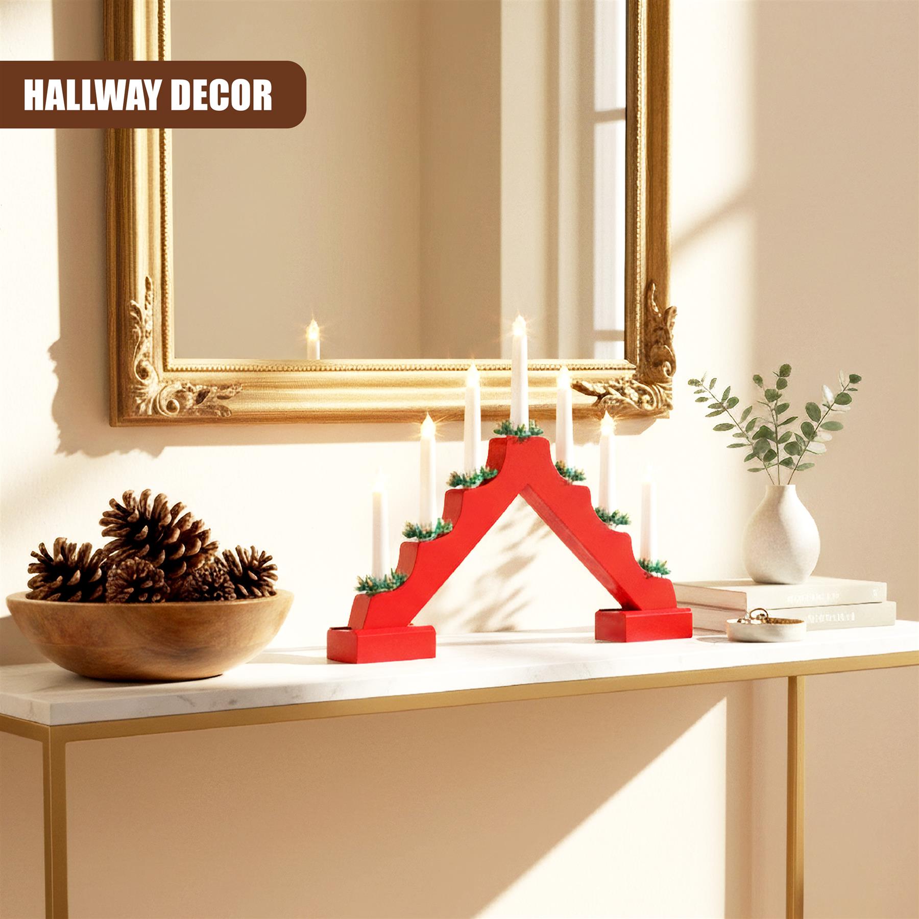 A modern, minimalist Christmas decoration featuring a red, 5-tiered candle holder with 5 white candles. The candle holder has a Christmas tree-like design, with each tier featuring a small green sprig. It is placed on a white, marble-topped table, with a gold-rimmed mirror hanging on the wall behind it. - The Magic Toy Shop