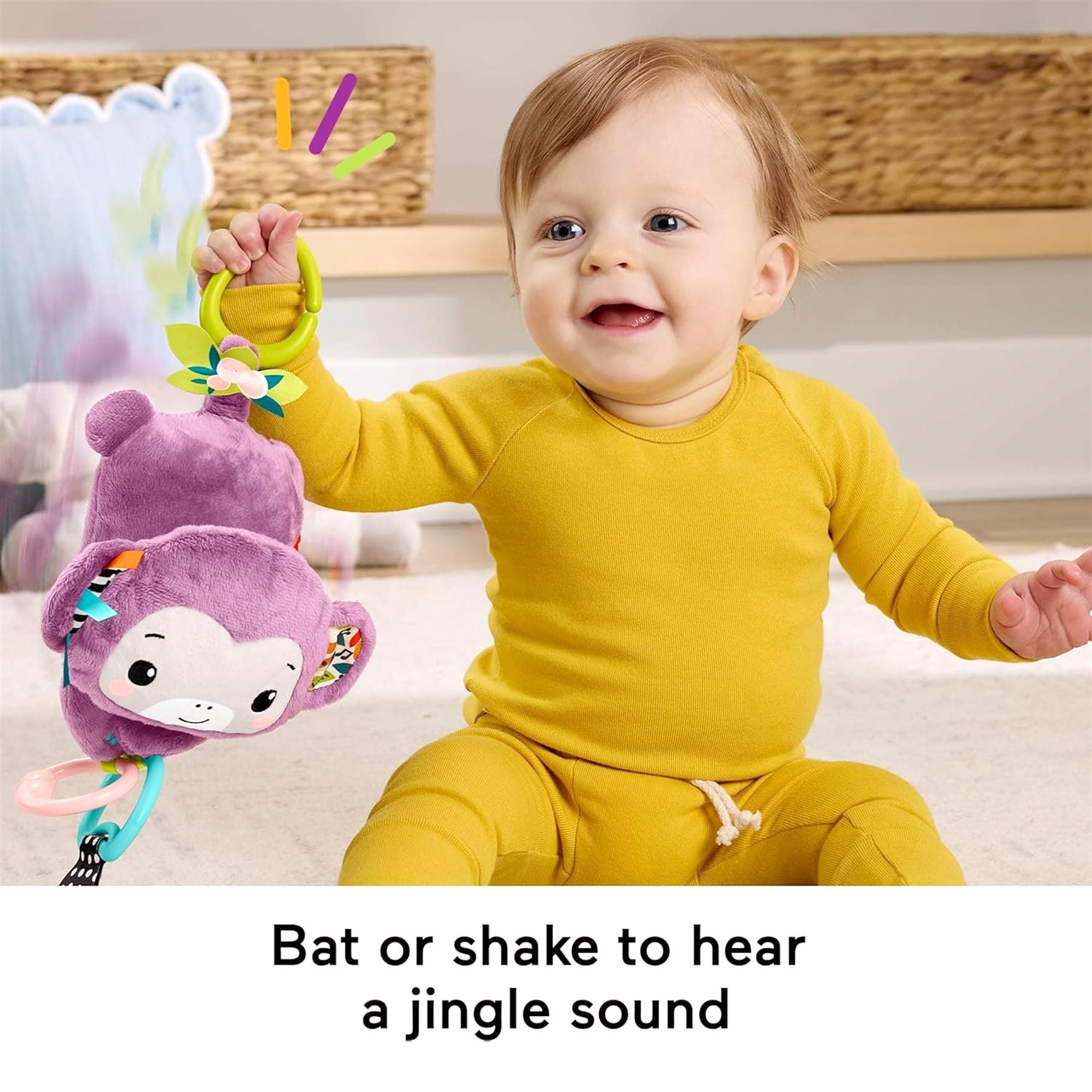 Baby seated with a purple monkey toy and matching baby stroller toy visible on the left.