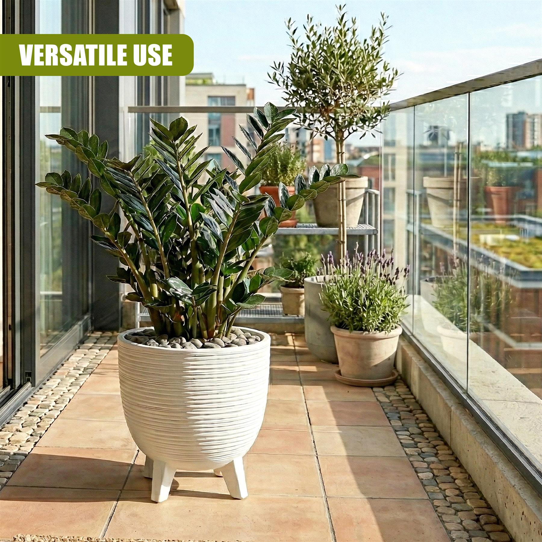 Large white striped pot on legs holding dense tropical greenery on a tiled outdoor patio.